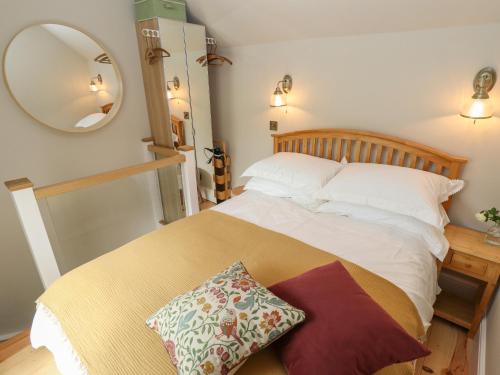 a bedroom with a large bed with a mirror at Hangmans cottage in Horncastle