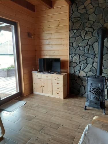 a living room with a fireplace and a stove at Chata gościom rada in Ustrzyki Dolne