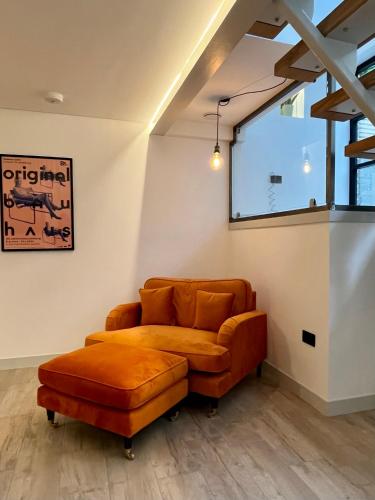 a living room with a brown couch and a window at Emery Street Lodge in Cambridge