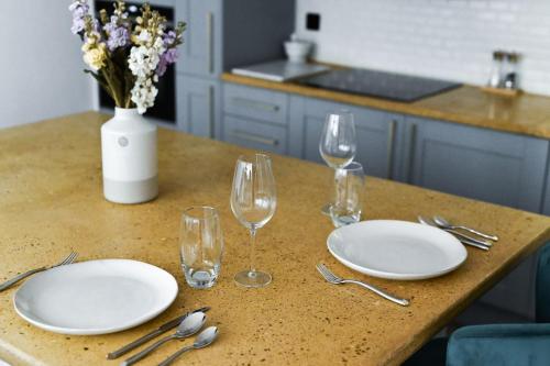 una mesa con dos platos blancos y copas de vino en Emery Street Lodge, en Cambridge