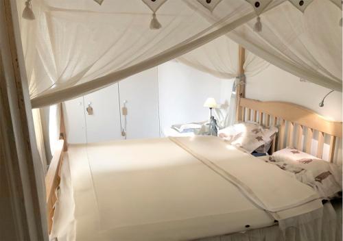 a white bed with a canopy in a bedroom at Lakeview in Casa Mia in Ljusdal