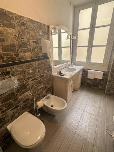 a bathroom with a sink and a toilet and a mirror at Hotel Dell'Orto in Chiavari