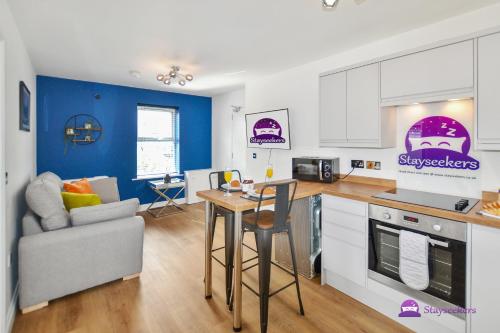 a kitchen and living room with a table and a couch at Annie 1 bed Apartment next to rail station - STAYSEEKERS in Salisbury