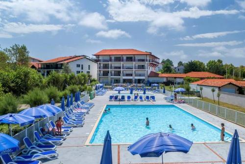 - une grande piscine avec des parasols bleus dans l'établissement T2 Saint Jean de Luz - Résidence Iratzia - 200m plage - Piscine - Tennis, à Saint-Jean-de-Luz