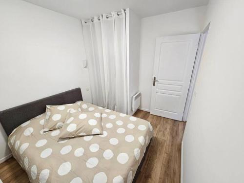 a bedroom with a bed with a polka dot sheets at T2 Saint Jean de Luz 200m plage in Saint-Jean-de-Luz