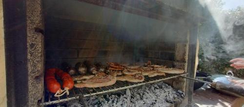 a grill with a bunch of food cooking on it at HOTEL RURAL LA ENGAÑA in Pedrosa