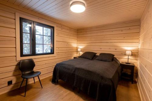 a bedroom with a bed and a chair and a window at Villa Levilla, luxury in Levi in Levi