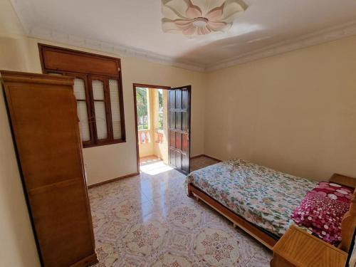 um quarto com uma cama e uma ventoinha de tecto em Large Family Apartment by Beach & center of town em Asilah