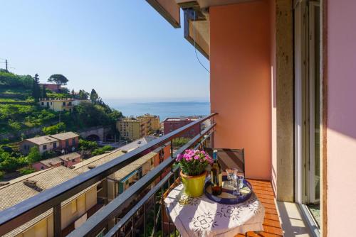 a balcony with a table with flowers and a view at Costasole in Monterosso al Mare