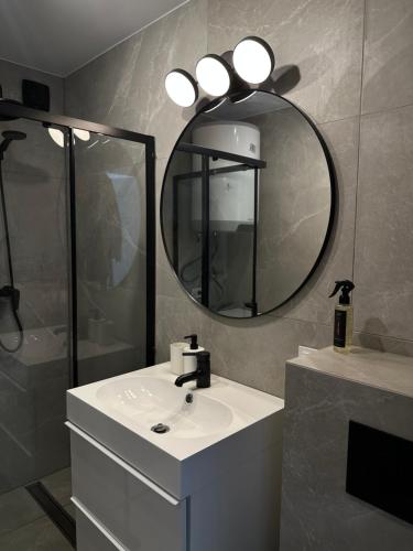 La salle de bains est pourvue d'un lavabo et d'un miroir. dans l'établissement LEYLA Apartments, à Nido