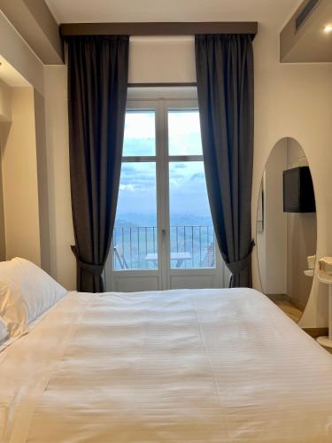 a bedroom with a large bed and a large window at Villa Nonna Cicci Boutique Hotel - SPA in Cisterna dʼAsti