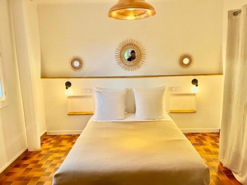 um quarto com uma cama com almofadas brancas e um espelho em Gite Harmonie em Gréoux-les-Bains