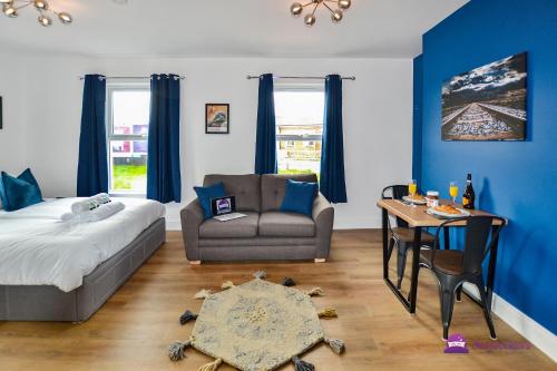 a bedroom with a bed and a couch and a table at Clarabel Studio Apartment - Stayseekers in Salisbury