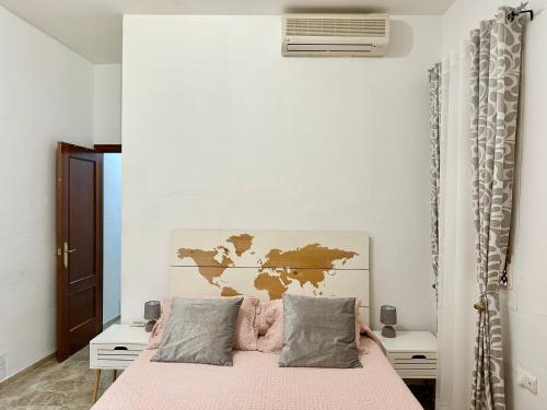Dormitorio con cama rosa y mapa en la pared en Apartamento acogedor y moderno en pleno centro de Sevilla con Parking Gratis, en Sevilla