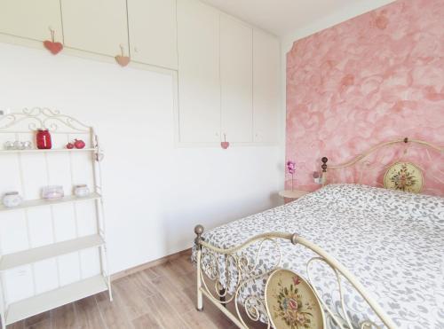 a bedroom with a bed and a pink wall at Tuscan Orchard in Montespertoli