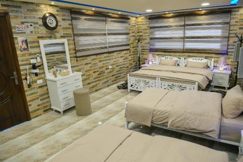 a bedroom with two beds and a brick wall at PETRA ROYAL HOUSE in Wadi Musa