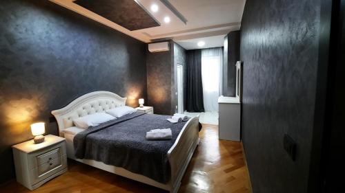 een slaapkamer met een bed, 2 lampen en een raam bij Makos Guest House in Koetaisi