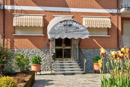 a brick building with an awning and flowers in front at Magnolia in Cisterna dʼAsti