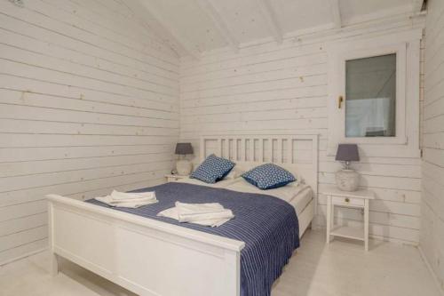 Dormitorio blanco con cama con almohadas azules en Casa Blanca Olimp, en Olimp