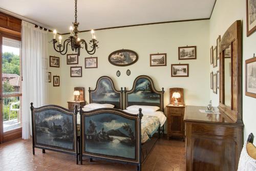 a bedroom with a bed and pictures on the wall at Magnolia in Cisterna dʼAsti