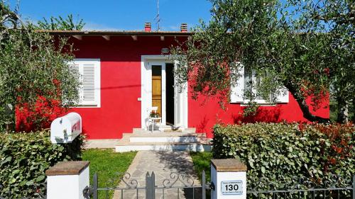 a red house with a white door at Tuscan Orchard in Montespertoli