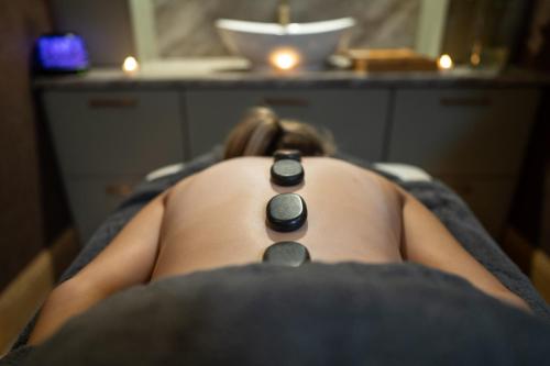 a woman laying on a bed with a black necklace at County Arms Birr in Birr