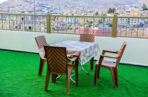 a table and chairs on a balcony with a view at PETRA ROYAL HOUSE in Wadi Musa