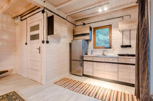 eine Küche mit Kühlschrank und Spüle in der Unterkunft Agropensjonat Stręgielek in Stręgielek