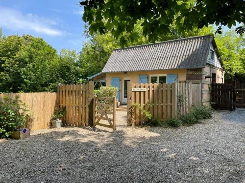 una pequeña casa con una valla y una puerta en Le Clos Marin cottage proche Deauville, en Cricquebœuf