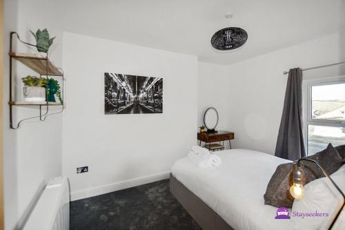 1 dormitorio con 1 cama y una foto en la pared en Thomas 1 bed Apartment with cathedral views - STAYSEEKERS, en Salisbury