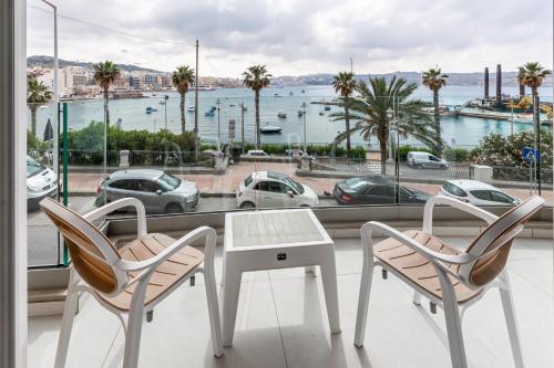 a table and two chairs and a view of a harbor at Seafront Luxury Apartment in St. Paul's Bay