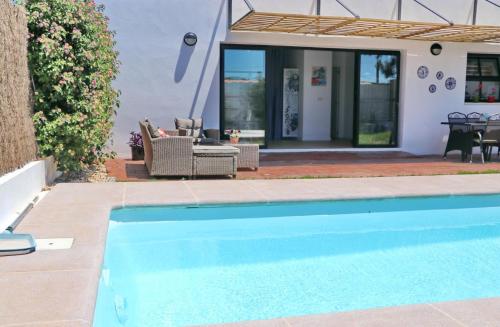 a swimming pool in front of a house at Chalet Isla Papua in Chiclana de la Frontera