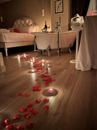 a room with red flowers on the floor and a bed at Villa Nonna Cicci Boutique Hotel - SPA in Cisterna dʼAsti