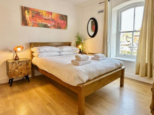 een slaapkamer met een bed met handdoeken erop bij Riverside Apartment at Woodsmill Quay in York