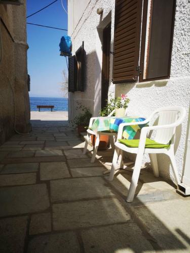 patio ze stołem i krzesłami oraz oceanem w obiekcie Maria's Studios yellow w mieście Afissos