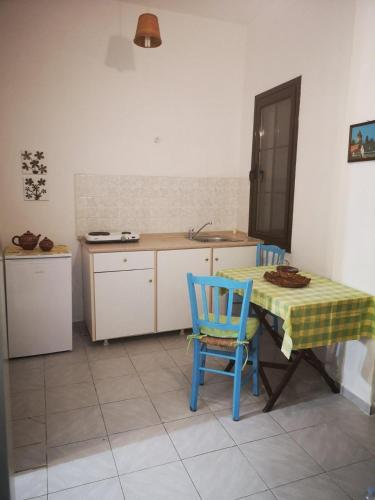 kuchnia ze stołem, 2 krzesłami i zlewem w obiekcie Maria's Studios yellow w mieście Afissos