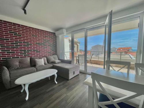 a living room with a couch and a brick wall at Bucanero Apartments Budva in Budva