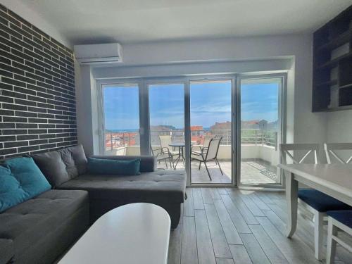 a living room with a couch and a balcony with a table at Bucanero Apartments Budva in Budva