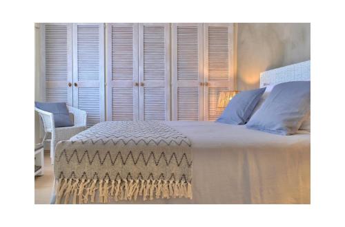 a bedroom with a large white bed with blue pillows at Les Jardins de Sitaara in Cucuron