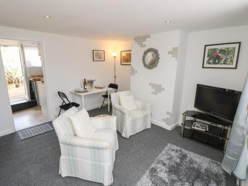 a living room with two chairs and a television at Castle Cottage in Newport