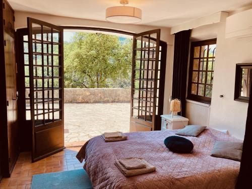 une chambre avec un lit et une porte ouverte dans l'établissement Villa with spectacular views - Pool house with outdoor kitchen and pizza oven, à Auribeau-sur-Siagne