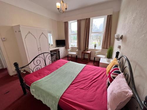 ein Schlafzimmer mit einem roten Bett und ein Wohnzimmer in der Unterkunft Born Park in Bournemouth