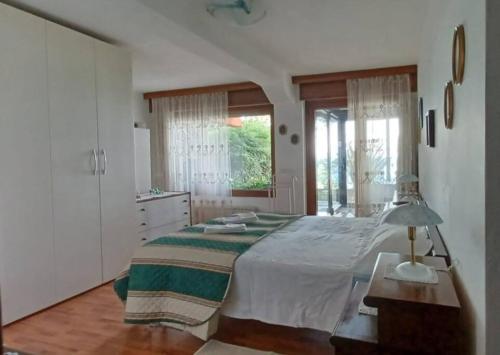 una camera con un grande letto e una finestra di Brezza Marina - Appartamento in villa fronte mare a Trieste