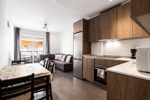 een keuken en woonkamer met een tafel en een bank bij Apt Fuengirola Old Town by Costarentals - Ref 181 in Fuengirola