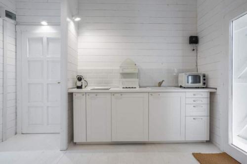una cocina blanca con microondas en una encimera en Casa Blanca Olimp, en Olimp
