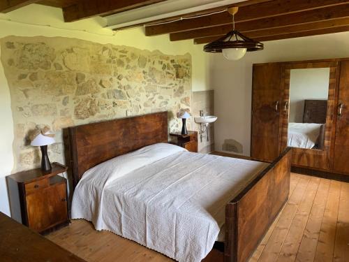 a bedroom with a large bed and a mirror at Agriturismo Al Vecio Caselo (Casa Maga) in Arsiero