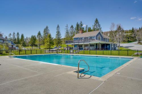 a swimming pool in front of a house at Ski-inandSki-Out Peru Condo with Fire Pit and Grill! in Peru
