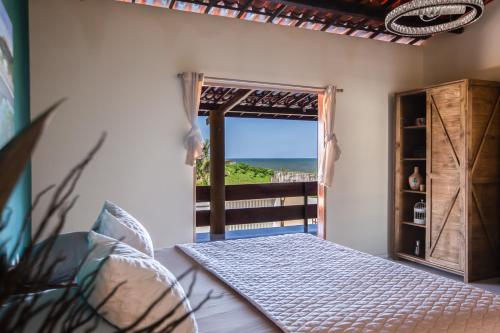 a bedroom with a bed and a view of the ocean at Casa Ferreira Cumbuco in Caucaia