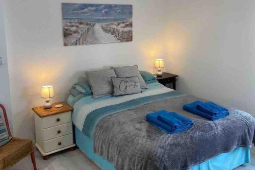 a bedroom with a bed with two blue towels on it at Stunning seaside studio in Worthing