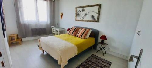 une chambre avec un lit avec une couverture jaune dans l'établissement 